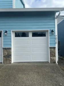 Modern garage door replacement on blue home