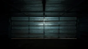 Closed metal garage door in dark garage interior