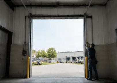 Garage door mechanic installing a commercial garage door