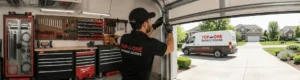 Garage technician repairing door with service van